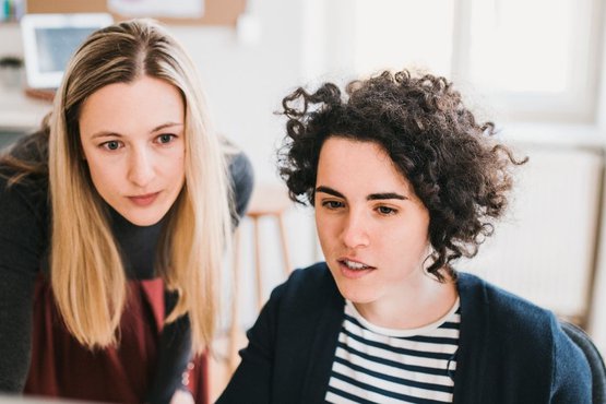 Zwei Lingovo Übersetzerinnen arbeiten an der Qualitätssicherung einer deutsch-englischen Übersetzung im Vier-Augen-Prinzip
